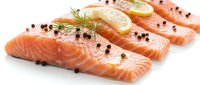 Fresh salmon fillets with lemon slices, dill and black peppercorns on white background. Raw fish portions ready for cooking, healthy seafood ingredient.