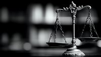 Dramatic black and white composition of scales of justice with ornate details against dark background with bokeh effect, symbolizing law, justice and legal system.