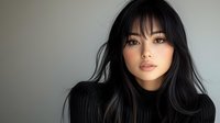 Young Asian woman with long black hair and bangs wearing dark turtleneck sweater against neutral background, looking at camera with serene expression. Professional portrait with soft lighting.