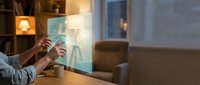 Designer working with digital holographic interface display on transparent screen in modern office workspace.