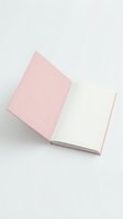 Open pink notebook with blank white pages on neutral background for creative writing and planning projects.