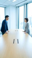 Asian business professionals having friendly conversation in modern conference room with city skyline view during corporate meeting.