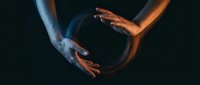 Two hands reaching toward each other in dramatic lighting creating connection and unity concept for teamwork, partnership, and human relationships.