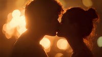 Romantic couple silhouettes kissing at sunset with warm golden bokeh lights creating intimate atmosphere for love and relationship concepts.