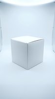 White cube box displayed in minimalist studio setting with soft overhead lighting, suitable for product mockups, packaging design presentations, and commercial advertising applications.