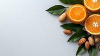 Fresh juicy orange slices with green leaves, almonds and peanuts arranged on light gray background creating corner composition with copy space.