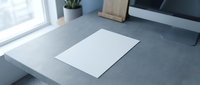 Blank white paper sheet mockup on modern gray concrete desk with computer and plant in bright office workspace.