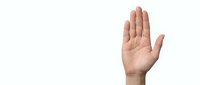 Human hand raised up in stop gesture showing palm on white background isolated for design and communication concepts.