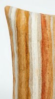 Striped woven cushion cover in warm earth tones featuring vertical bands of gold, rust, cream and beige. Soft textile fabric with natural texture, isolated on white background, ready for home decor design use.