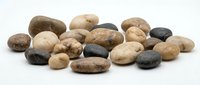 Collection of smooth river rocks and pebbles in natural earth tones isolated on white background for spa, meditation, zen garden and decorative design projects.