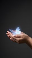 Cupped hands holding glowing translucent butterfly with iridescent wings against dark background symbolizing hope, transformation and spiritual growth.