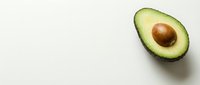 Fresh avocado half with pit on white background, suitable for food, nutrition, healthy eating, and culinary content.
