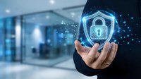 Businessman holding glowing padlock shield icon with digital particles, representing cybersecurity, data protection, and network security solutions for business.