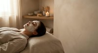 Young Asian woman relaxing with cucumber eye mask during spa facial treatment in serene wellness center for skincare and beauty routine.