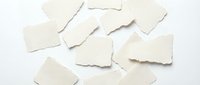 Torn white paper pieces scattered on white background, perfect for collage, scrapbooking and creative design projects with realistic texture and edges.