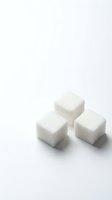 Three white sugar cubes arranged on a light background, isolated and ready for culinary, beverage, and food styling design projects.