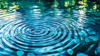 Concentric ripples on turquoise water surface with sunlight reflections creating mesmerizing circular pattern. Natural abstract background showing liquid motion and waves.