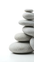 Stacked smooth gray stones isolated on white background, symbolizing balance, wellness, and zen meditation for spa and mindfulness design projects.