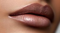 Close up of plump glossy lips with dark brown metallic lipstick showing texture and shine detail against smooth skin, suitable for beauty and cosmetic advertising.
