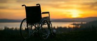 Silhouette of empty wheelchair positioned outdoors against golden sunset sky and serene lake landscape, symbolizing hope, recovery, and accessibility for medical and wellness campaigns.