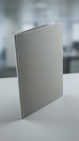 Blank gray notebook or journal standing upright on white surface with blurred office background for business branding and stationery mockup designs.