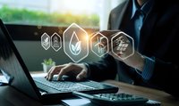 Professional businessman using laptop with glowing sustainability icons representing green energy, recycling and environmental technology solutions.