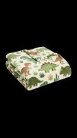 Folded soft fleece blanket with green dinosaur print, isolated on transparent background. Great for product mockups, kids bedding catalogs, and print on demand design use.
