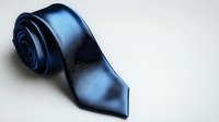 Elegant navy blue silk necktie with satin finish on light background, classic menswear accessory for formal and business attire.