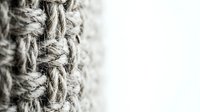 Natural jute rope with frayed fibers and twisted texture on white background, isolated for nautical maritime design projects and rustic crafts.
