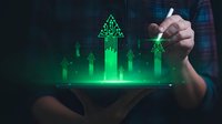 Businessman hand touching holographic green growth arrows and charts on tablet screen showing financial success and business development analytics.