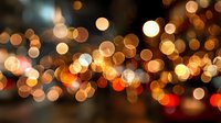 Abstract golden bokeh lights creating a warm atmospheric background with blurred circular light spots in various sizes.