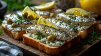 Open sandwiches with marinated sardines, capers, fresh herbs and lemon slices served on rustic wooden board. Mediterranean appetizer for seafood menu.