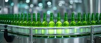 Green beer bottles lined up on industrial conveyor belt in beverage production facility, manufacturing and packaging process.