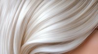 Luxurious platinum blonde hair waves close-up showing smooth, silky texture and natural shine against soft skin tone background for beauty and haircare advertising.