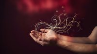 Magical golden swirls and sparkles floating above open hands against dark red background for fantasy and mystical design projects.