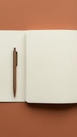 Open notebook with blank pages and bronze pen on terracotta background, suitable for stationery, office, education, and business design projects.