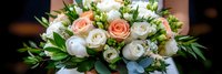 Elegant bridal bouquet with peach and white roses, ranunculus flowers and eucalyptus leaves for wedding ceremony and romantic celebration events.