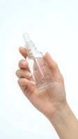 Female hand holding clear glass dropper bottle with pipette for skincare serum or essential oil on white background isolated for cosmetic design.
