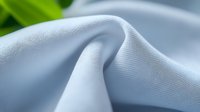 Soft light blue fabric with natural folds and texture, perfect for textile design, fashion projects, and creative backgrounds.