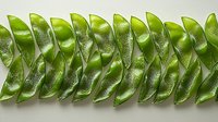 Fresh green sugar snap peas arranged in geometric pattern on white background, showing natural texture and symmetry for food photography and healthy eating concepts.