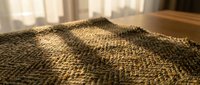Close-up of natural woven textile with warm golden tones and intricate diagonal weave pattern, suitable for interior design, fabric selection, and home decor projects.