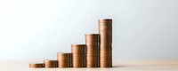 Growing stacks of copper coins arranged in ascending order on wooden surface against neutral background showing financial growth and investment progress.