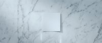 Blank white business card mockup on elegant marble surface with soft shadows for branding and corporate identity design projects.