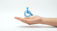 Caucasian hand holding blue wheelchair accessibility icon symbol, representing disability support, care services, and inclusive healthcare assistance.