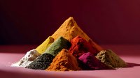 Vibrant colorful spice powders arranged in pyramid formation on dark background with dramatic lighting, showcasing diverse culinary ingredients and seasonings.