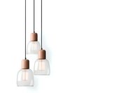 Modern pendant lights with clear glass shades and copper-colored holders hanging against white background, minimalist contemporary lighting design.