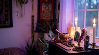 Cozy spiritual meditation room with candles, crystals, plants and mystical decor creating peaceful ambiance for wellness practices and mindfulness rituals.
