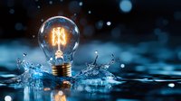 Glowing vintage light bulb with illuminated filament splashing in water against dark background with bokeh lights creating magical atmosphere.