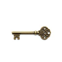 Antique brass ornate skeleton key with decorative scrollwork head isolated on white background for vintage design projects and crafting applications.