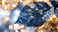 Macro shot of translucent blue autumn leaf with delicate veins against blurred golden bokeh background creating magical nature atmosphere. Seasonal artistic photography.